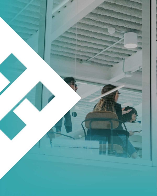 Professionals in a glass-walled meeting room having a focused strategic discussion