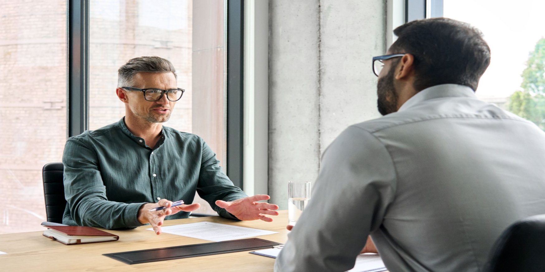 Advisor and client consulting at a desk in an office reviewing Microsoft Licensing