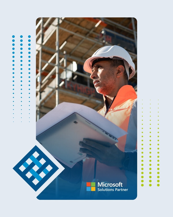 Construction manager in a white hard hat and orange hi-vis vest holding a tablet and looking up at a steel-scaffold building site