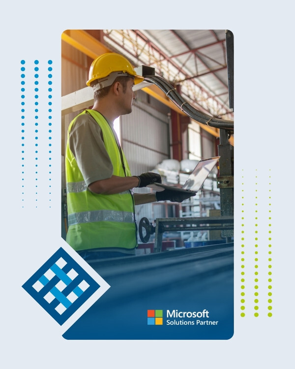 Manufacturing worker using a laptop beside industrial production equipment Manufacturing worker using a laptop beside industrial production equipment