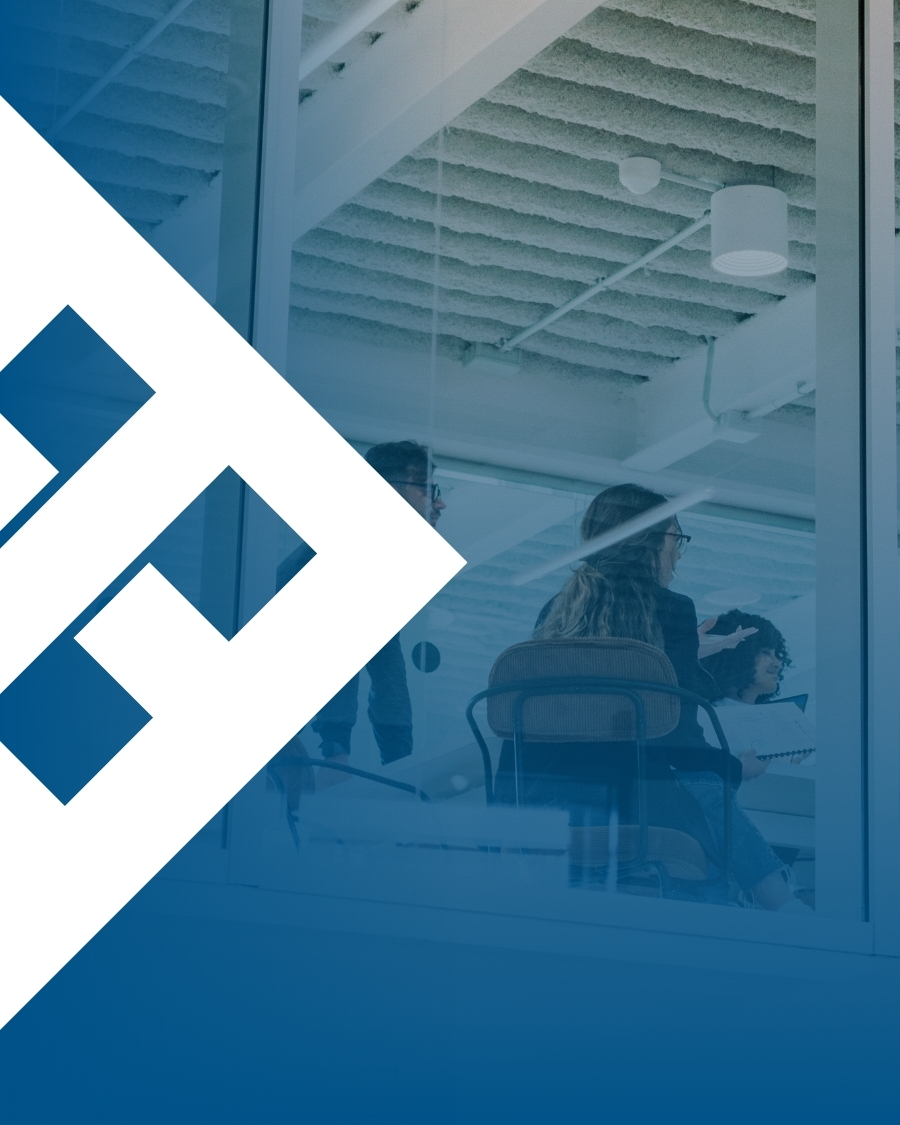 Three professionals in a modern glass-walled meeting room mid-discussion, representing strategic digital transformation planning for construction firms